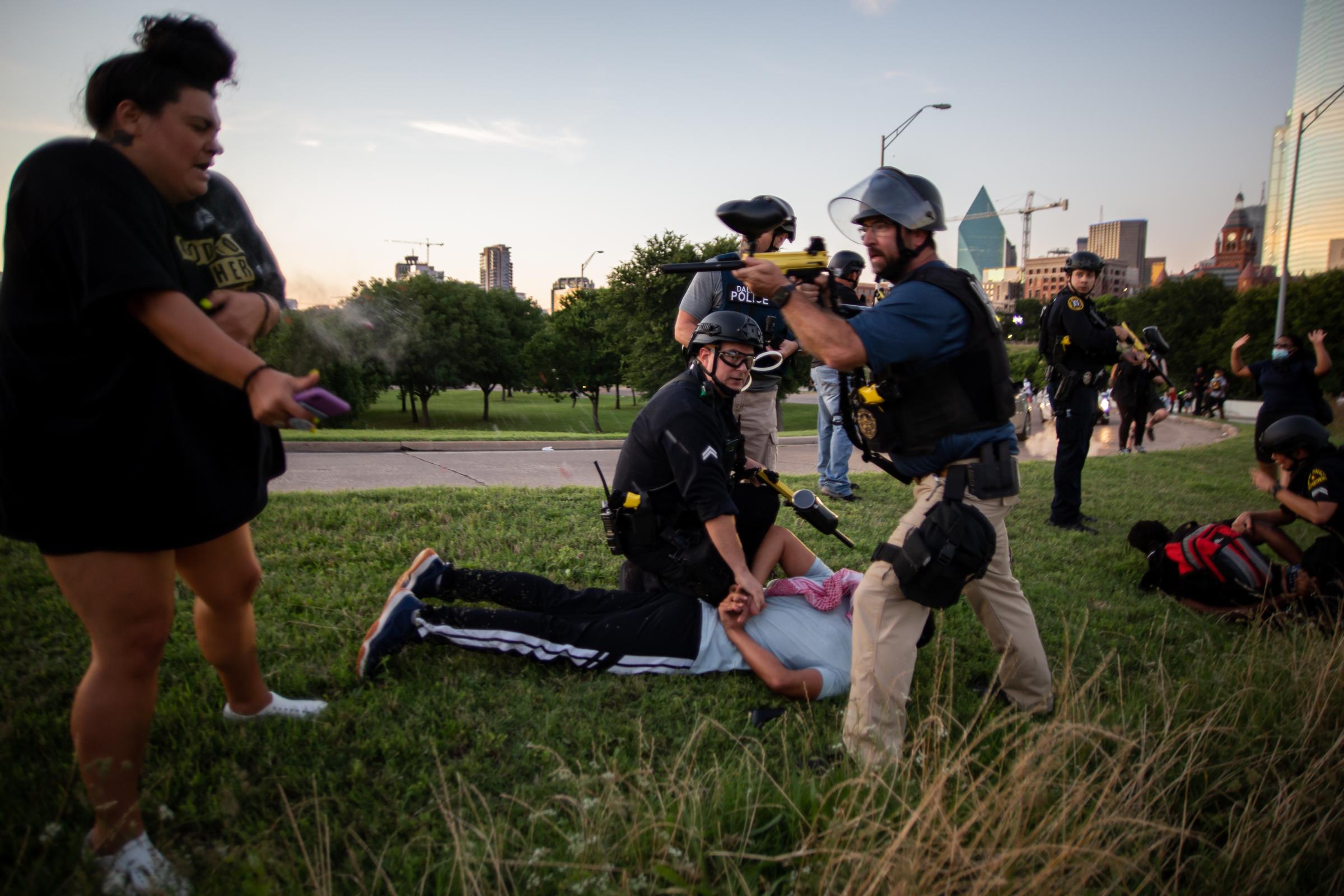 Landing Page - A Dallas Police Officer shoots pepper balls at a peaceful...