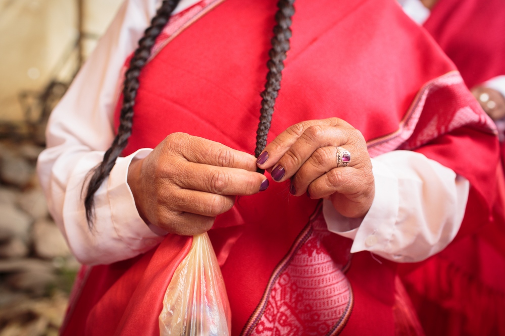 Chutanacuy!  -  A woman braids her hair and dresses in traditional...