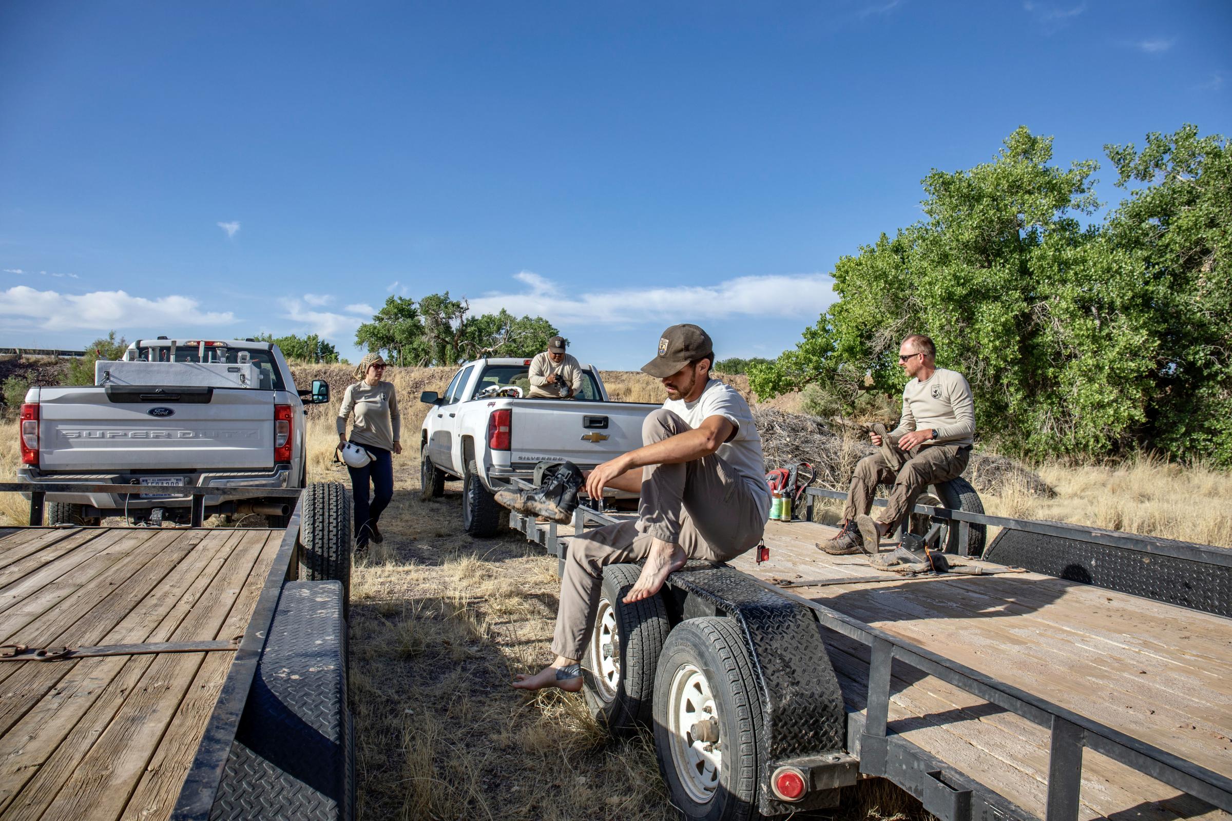 Crisis on the Rio Grande - Four team members, left, at the U.S. Fish and Wildlife service pull on their shoes before a fish...