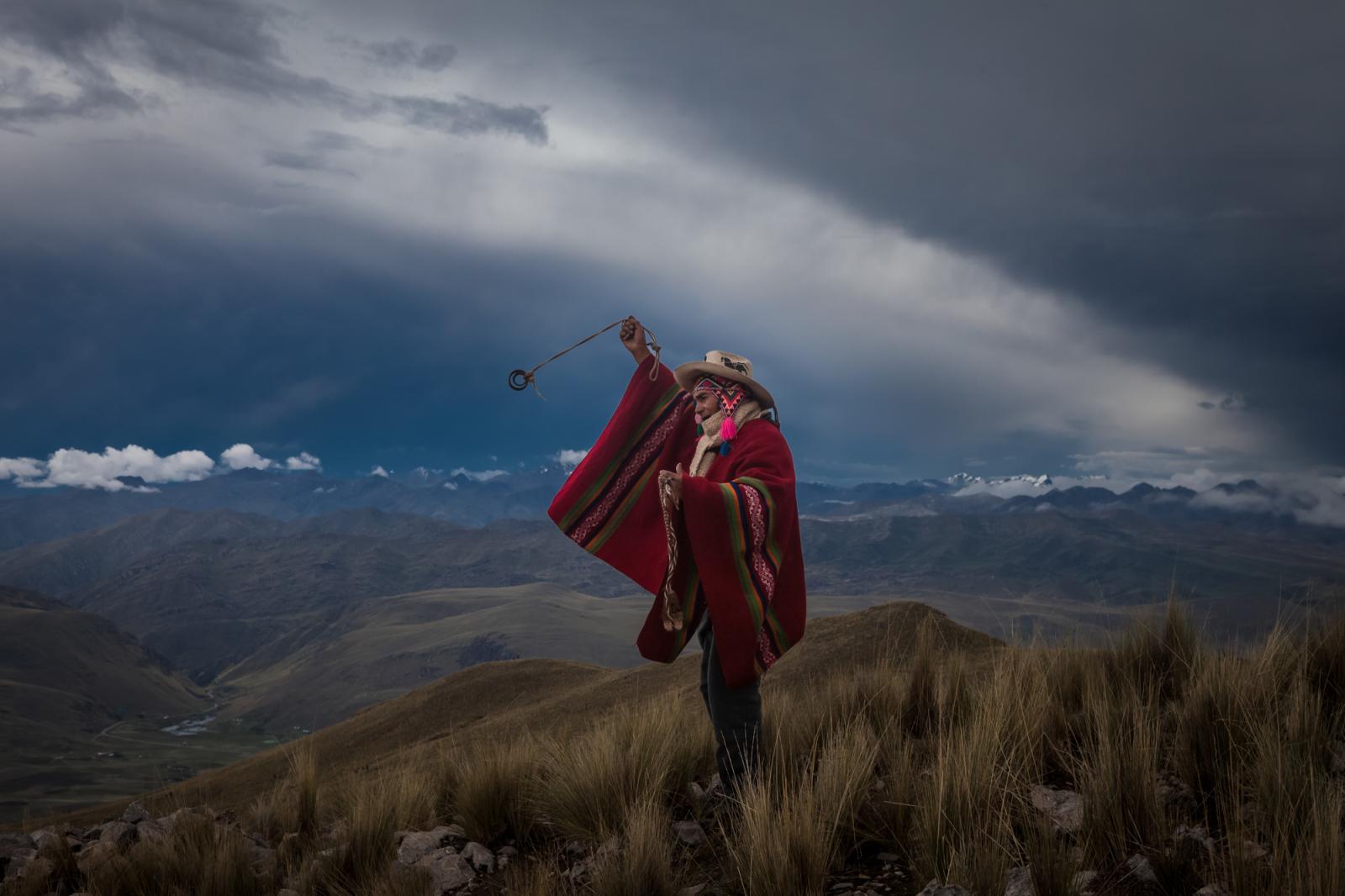 A man using a slingshot or huar... everything away. Chiaraje Peru