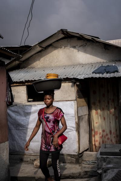 Unusual Niger Delta - A young girls walks past houses in Marine base waterfront...
