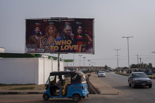 Unusual Niger Delta - Motorists drive past a billboard advert for a Nollywood...