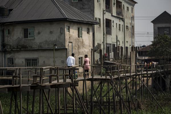 Unusual Niger Delta - People walk on a wooden bridge constructed by a private...