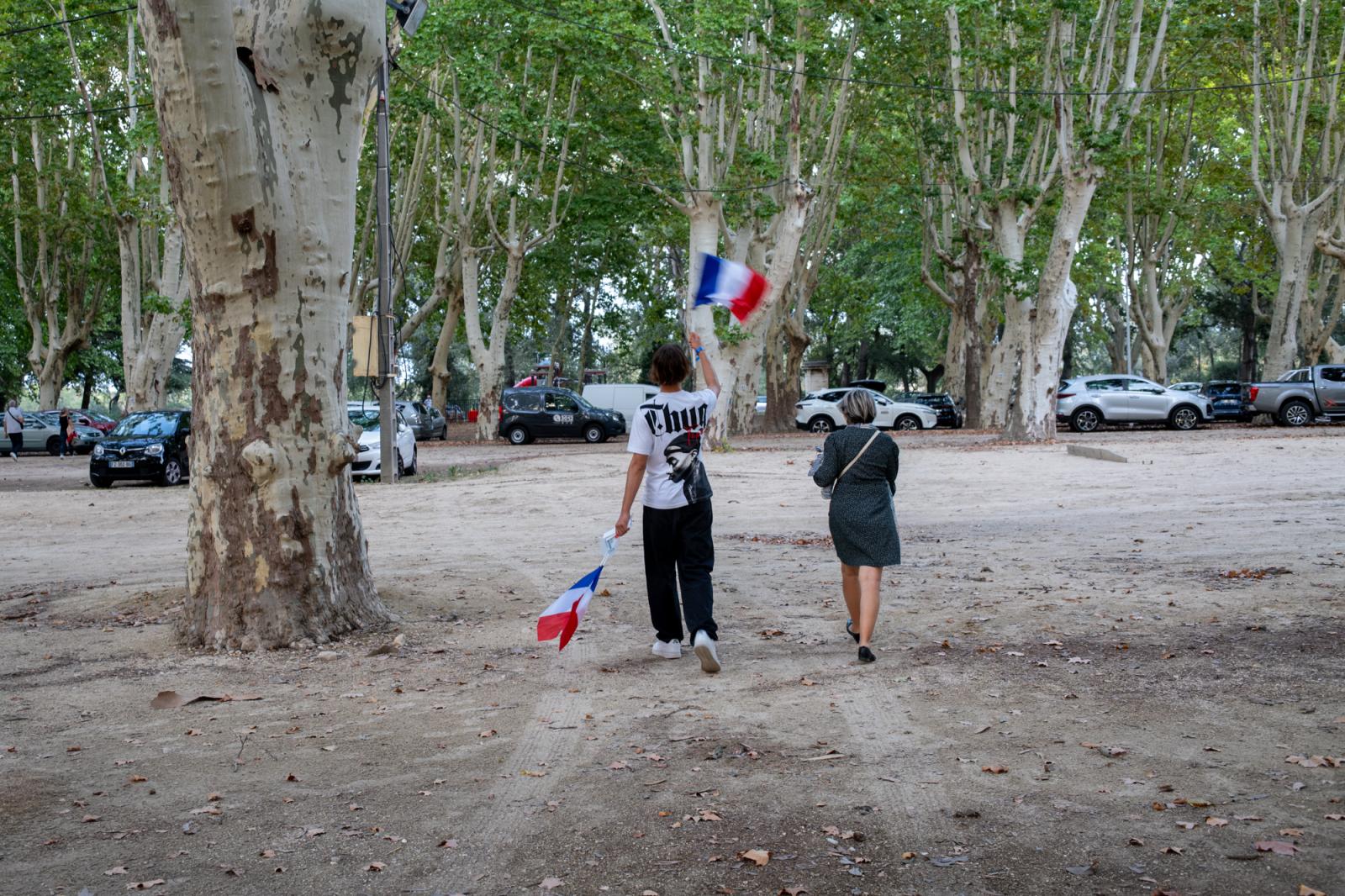 Image from politics - A mother and her son wave French flags as they leave...