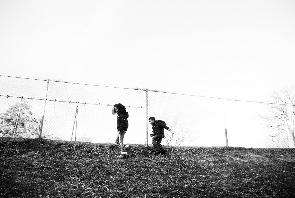 Exoneration: Life After Innocence -  Carissa and Fernando, Jr. play along a fence after school. 