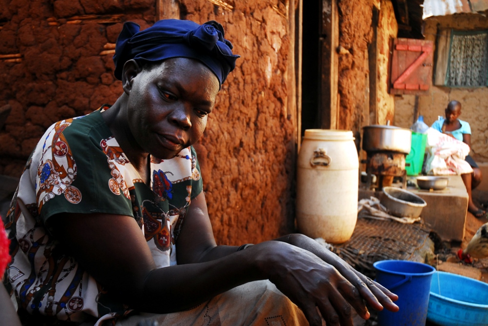  Alice, a home brew gin maker, stands in front of her home in a slum outside Kampala. Uganda,...