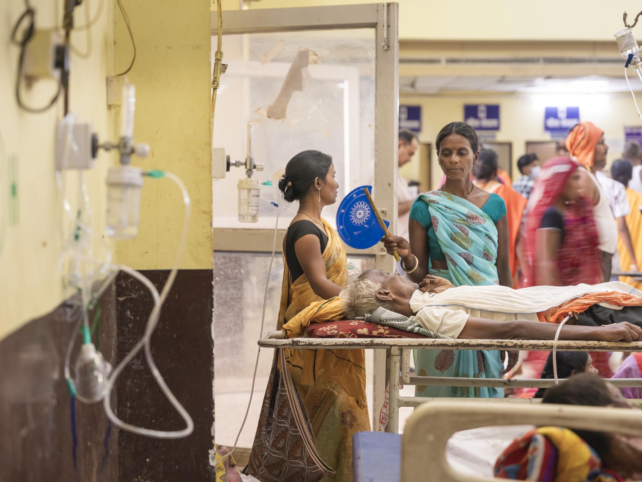 A woman fans a family member in...ospital (ANMCH) in Gaya, Bihar.