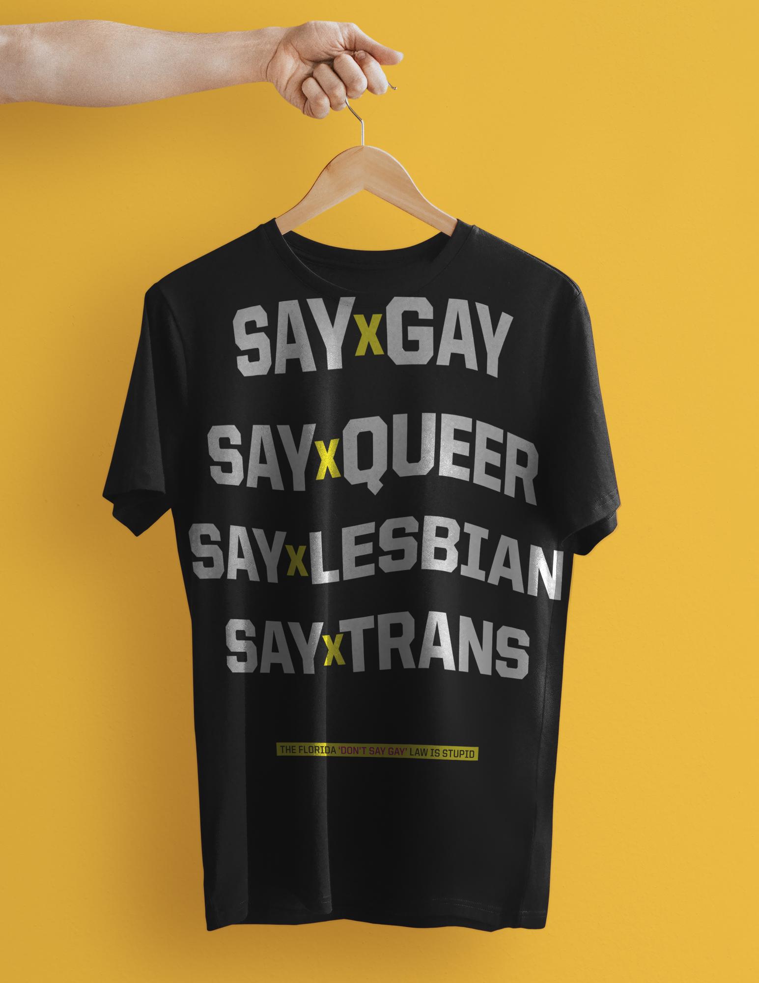 Say Gay (Workshop Designs) - Simple t-shirt mockup psd in black with hand holding hanger