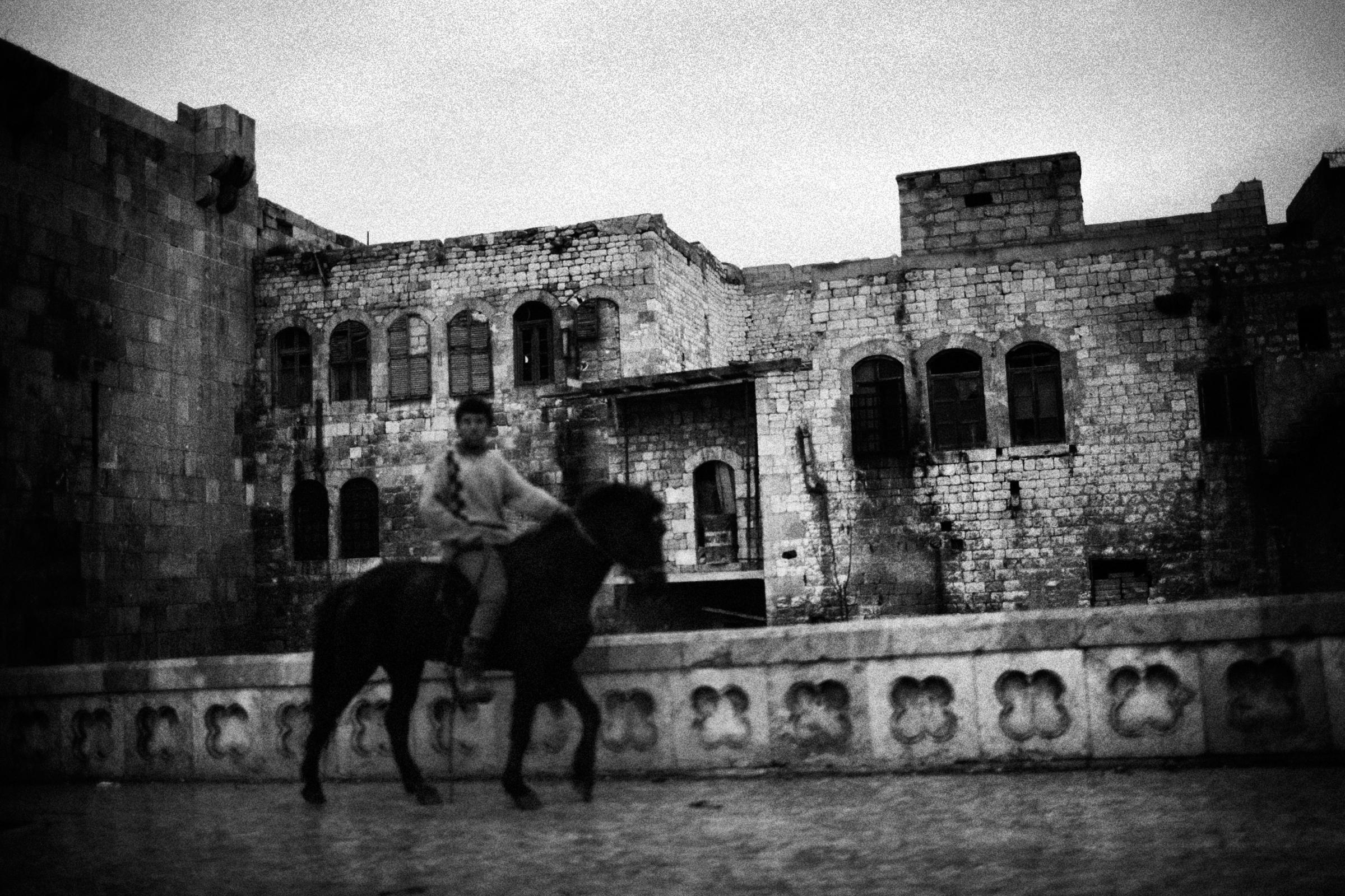 Alepo Scaring Frontlines - A boy riding a horse near the Old Town frontline of...