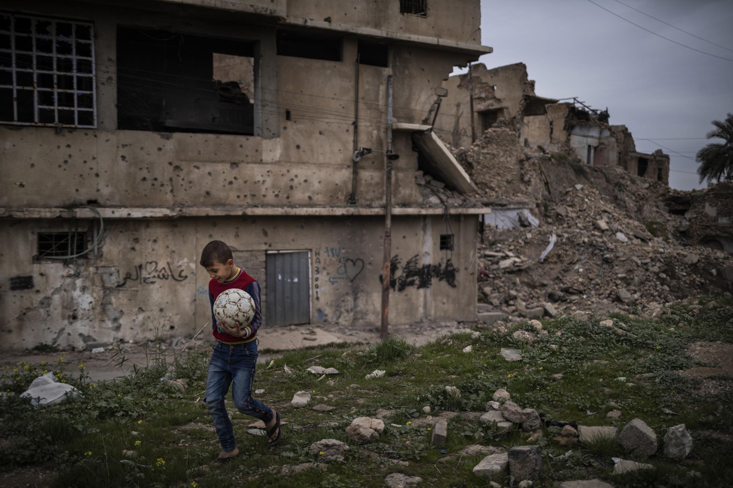 EWIPA Iraq - On 6 March 2022. Mosul, Iraq. A young Iraqi boy carries a...