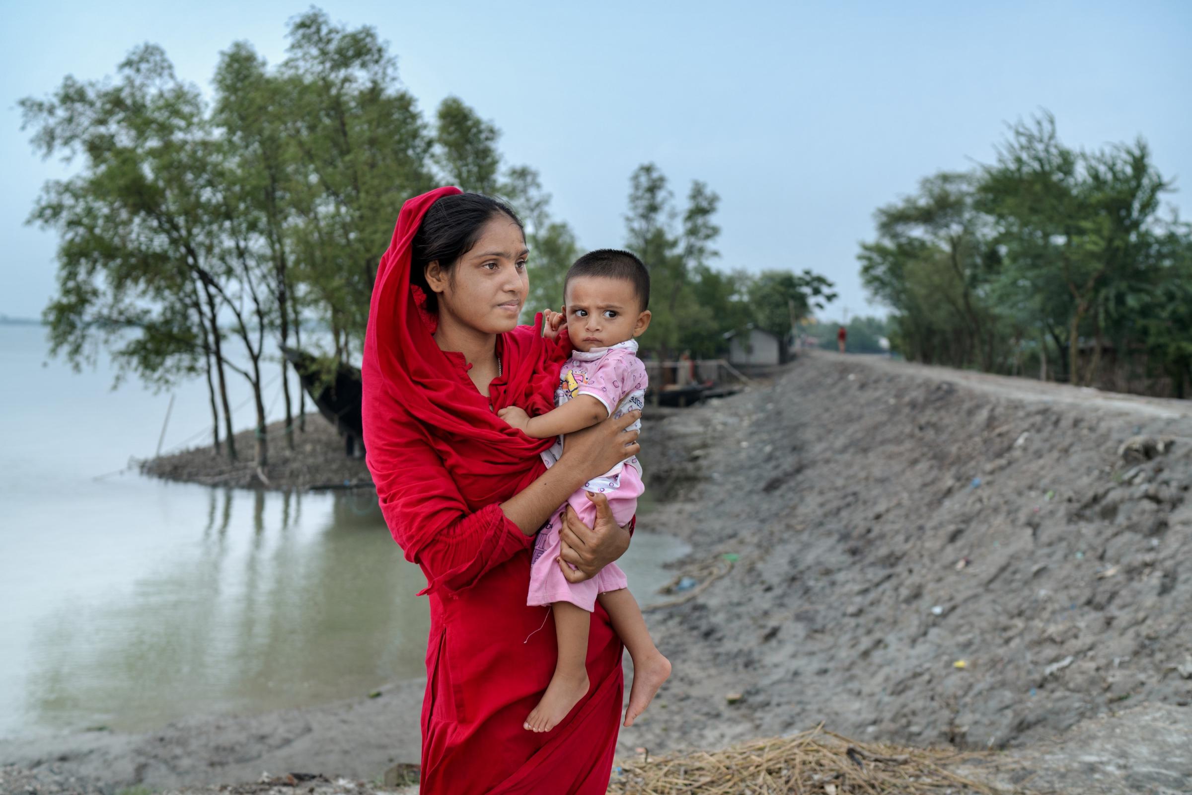 Child marriage in Bangladesh - Hira Moni, 15, holds her 8-month old son, Mohammad. She...