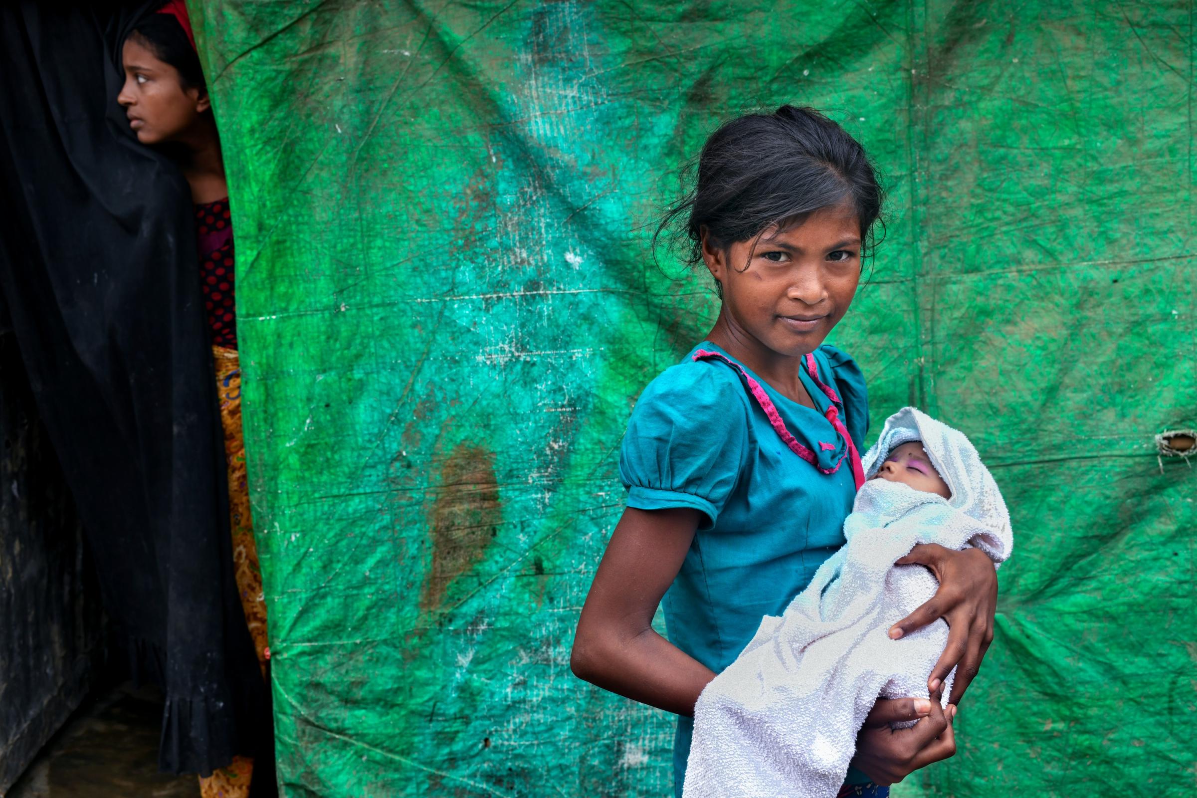 Rohingya Crisis - Nooreja is holding her new born sister outside their...