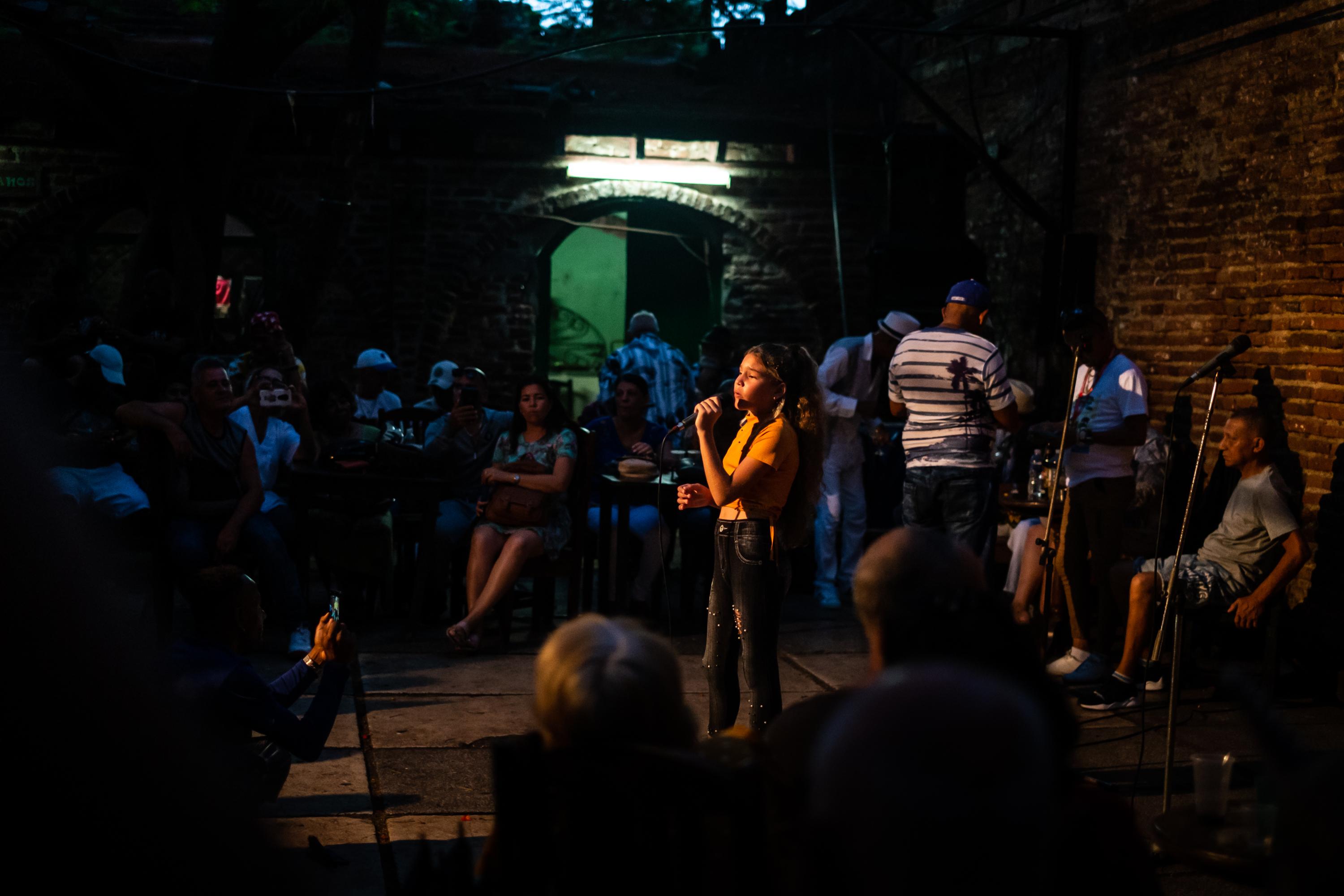 EL MEJUNJE -   A child singing in front of the crowd.  