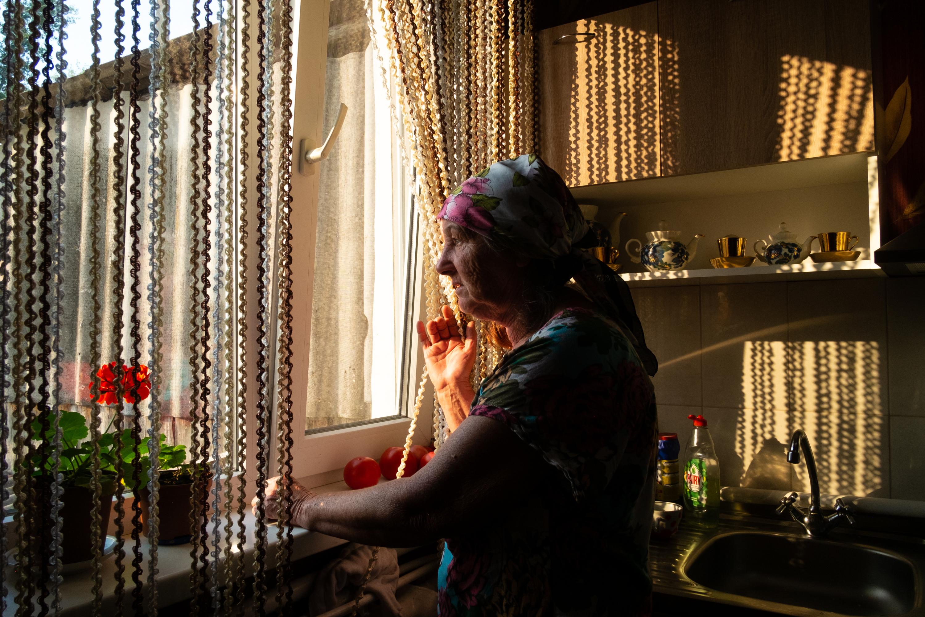 THE RETURN OF VIKA -   Vika's grandmother looking through the window. She...
