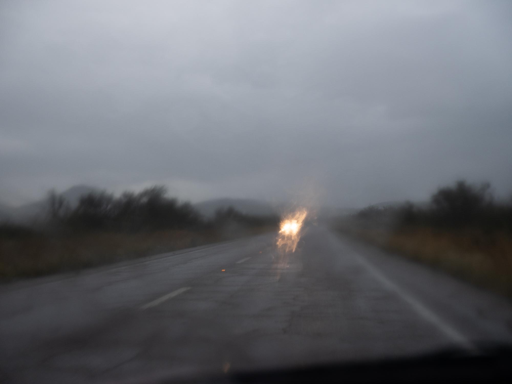 New Arizonans - HuffPost - Approaching headlights blur in the rainfall between...