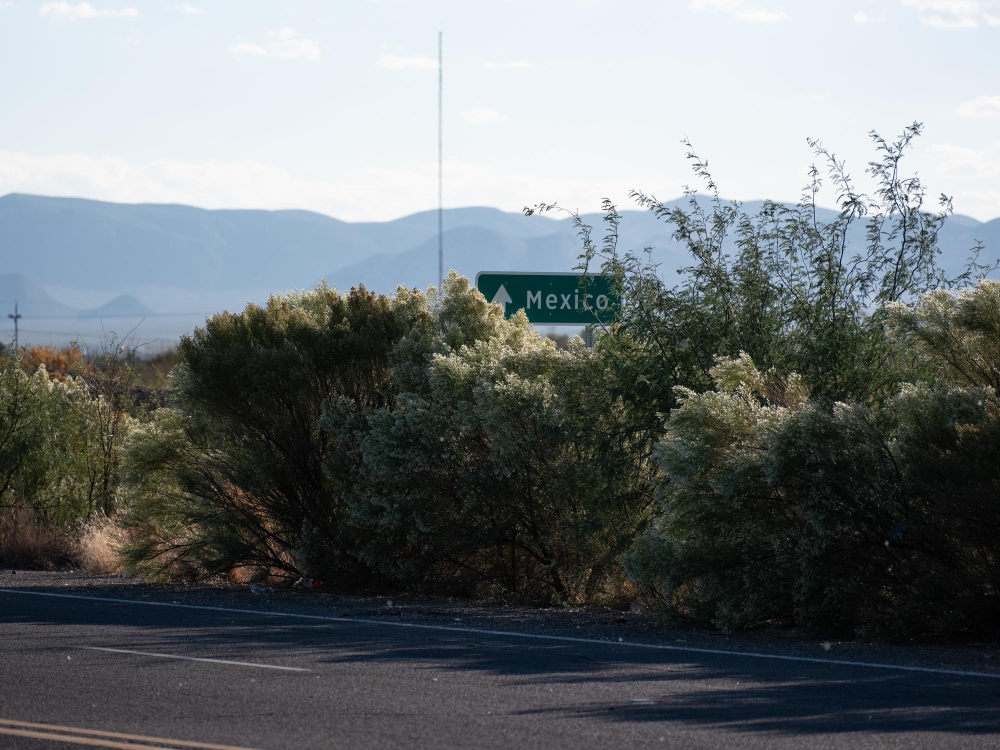 Social Media Migrant Smuggling - Bloomberg Businessweek - A sign directs vehicles heading for Mexico in Douglas, AZ. 