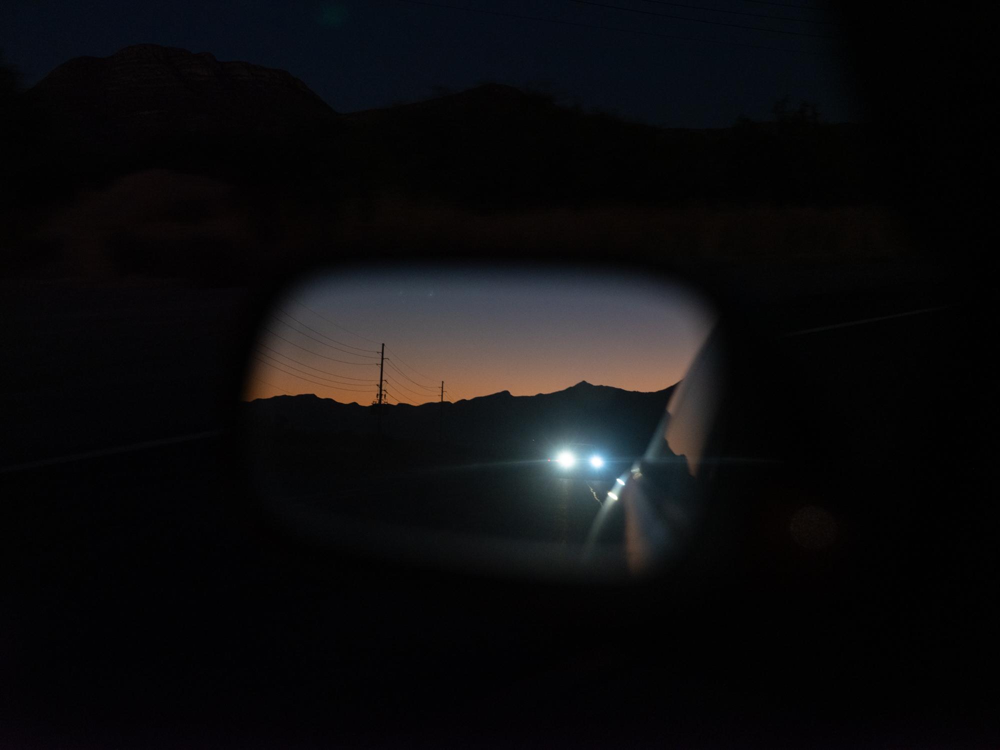 Social Media Migrant Smuggling - Bloomberg Businessweek - Headlights follow a car near Bisbee, AZ, an area along...