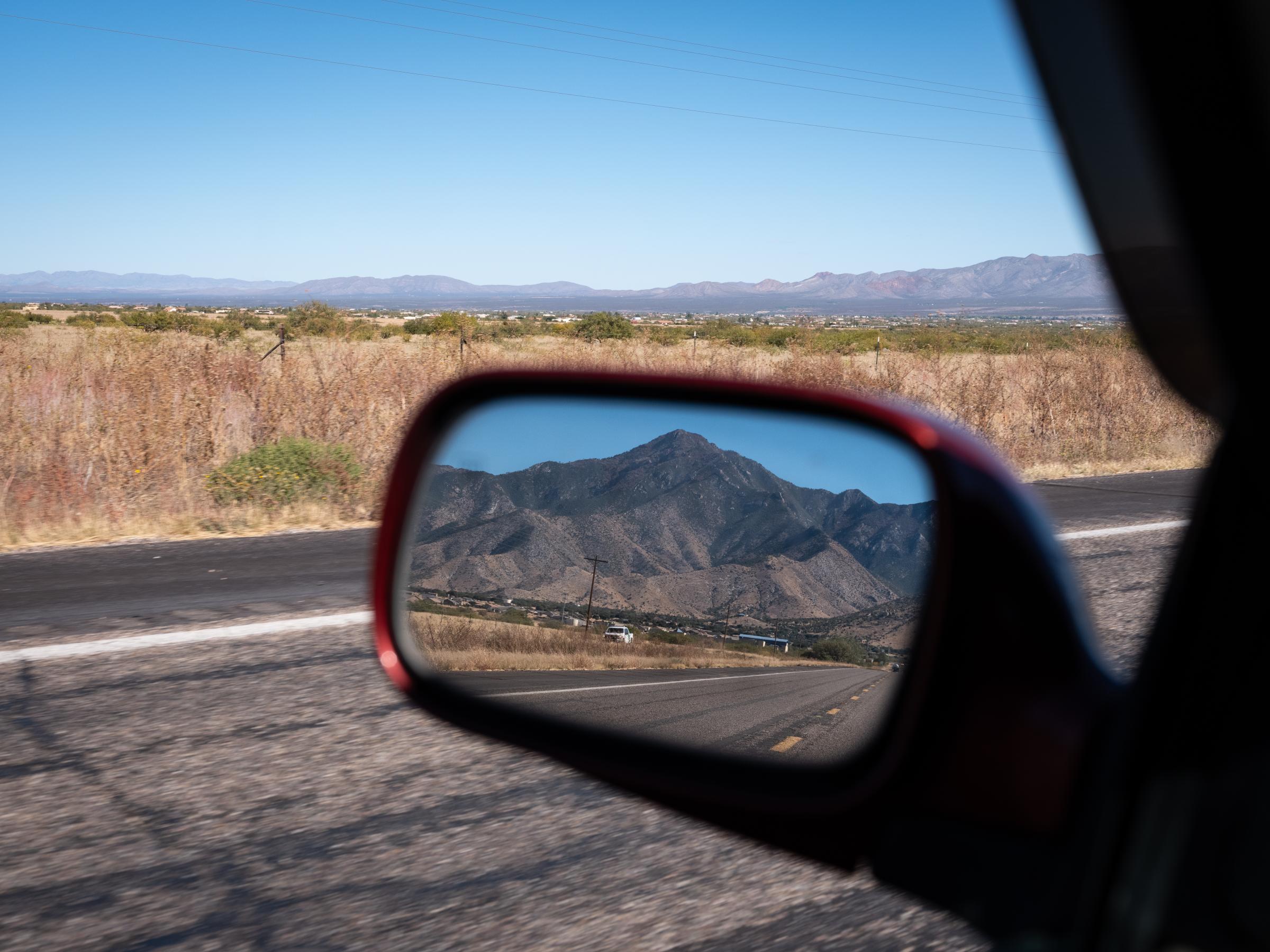 A border patrol vehicle is seen in the side mirror of a car driving along Rt. 92 in Hereford, AZ. Rt. 92 is a common pickup point for migrants...