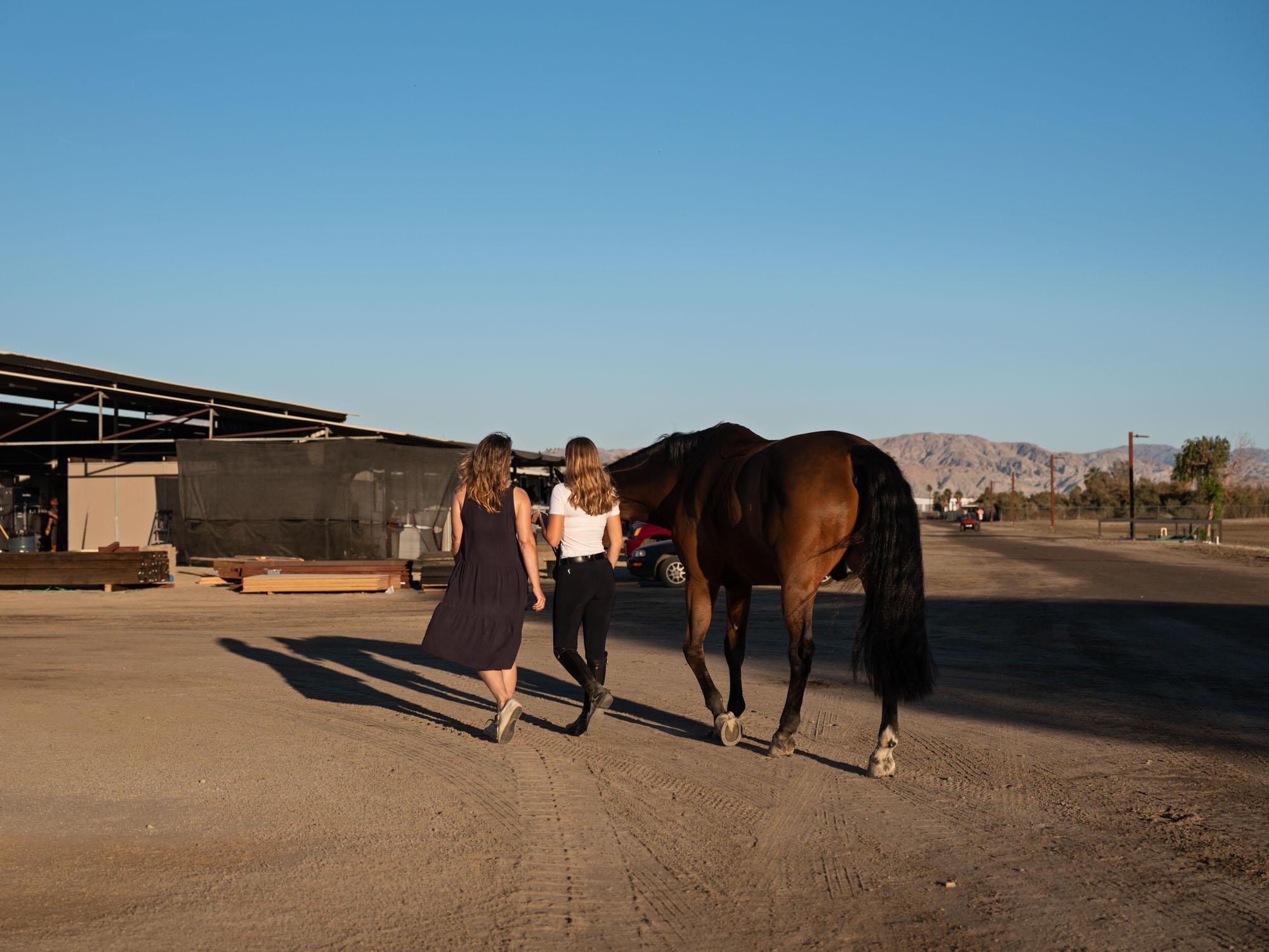 Maggie Kehring and her mother Carrie Kehring lead her horse, Agano back to his stall at the Desert International Horse Park.