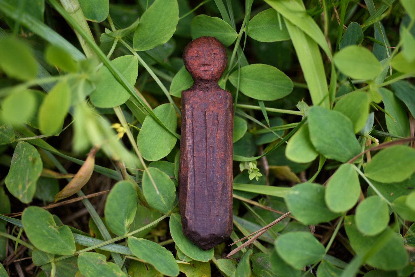 A wooden doll covered in red ochre is pulled from an unearthed sod house near Quinhagak, Alaska....