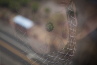  Melanie Dillon, 34, a sex trafficking survivor in Columbus, Ohio, is reflected in a window. Dillon was tattooed by her trafficker with his name. Thanks to a new local grassroots project created by another sex trafficking survivor, he had her chest tattoo covered with butterflies, her symbol of hope and recovery.   