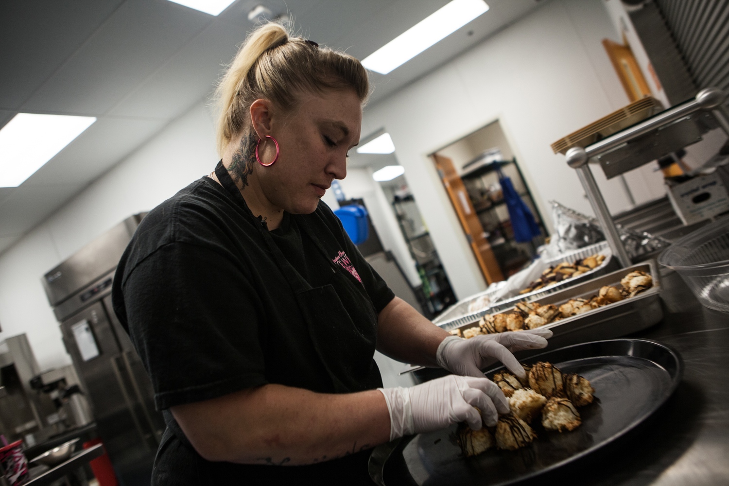 Survivors Ink -    Jennifer Kempton, 32, puts cookies in a catering plate...