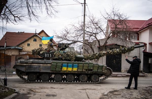 Image from Ukraine - An elderly man waves at a Ukrainian tank in the recently...