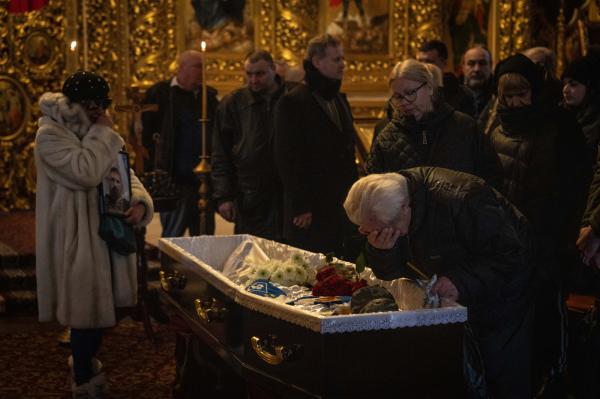 Image from Ukraine - An elderly man mourns in front of the open casket at the...