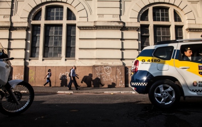  A police car patrols The Fluxo, in Cracolandia, Sao Paulo, while commuters walk by it. When officers have enough proof to arrest someone for dealing crack, theyâ€™ve learned the lesson to do it a few blocks away from The Fluxo to avoid heavy confrontations with the users.  