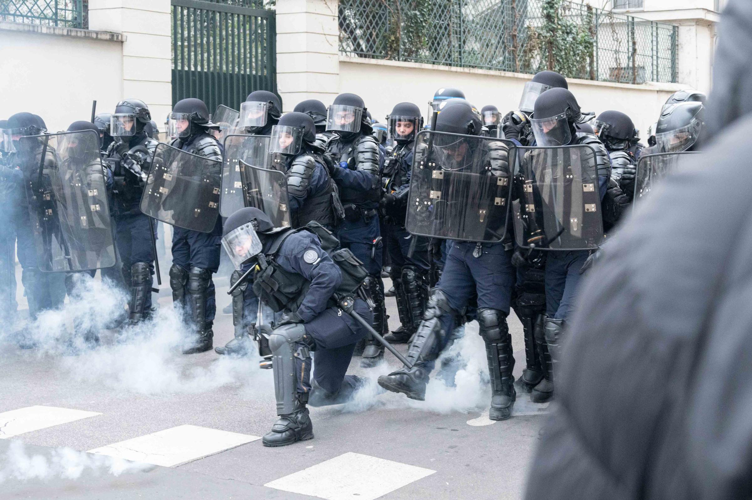 64 ans c'est Non ! -  Des policiers rejettent des palets de gaz lacrymogène...