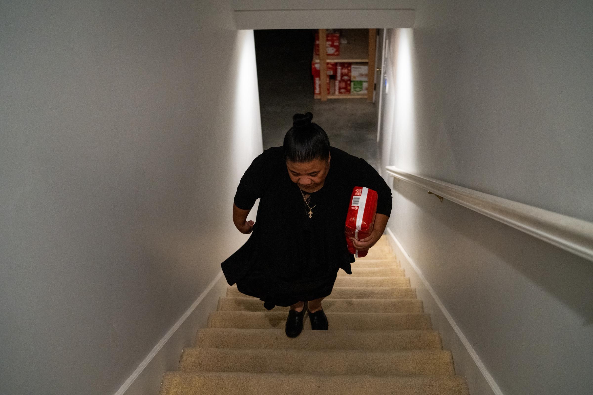 A House Full of Blessings - Sr. Anita carries a package of diapers up the stairs from...
