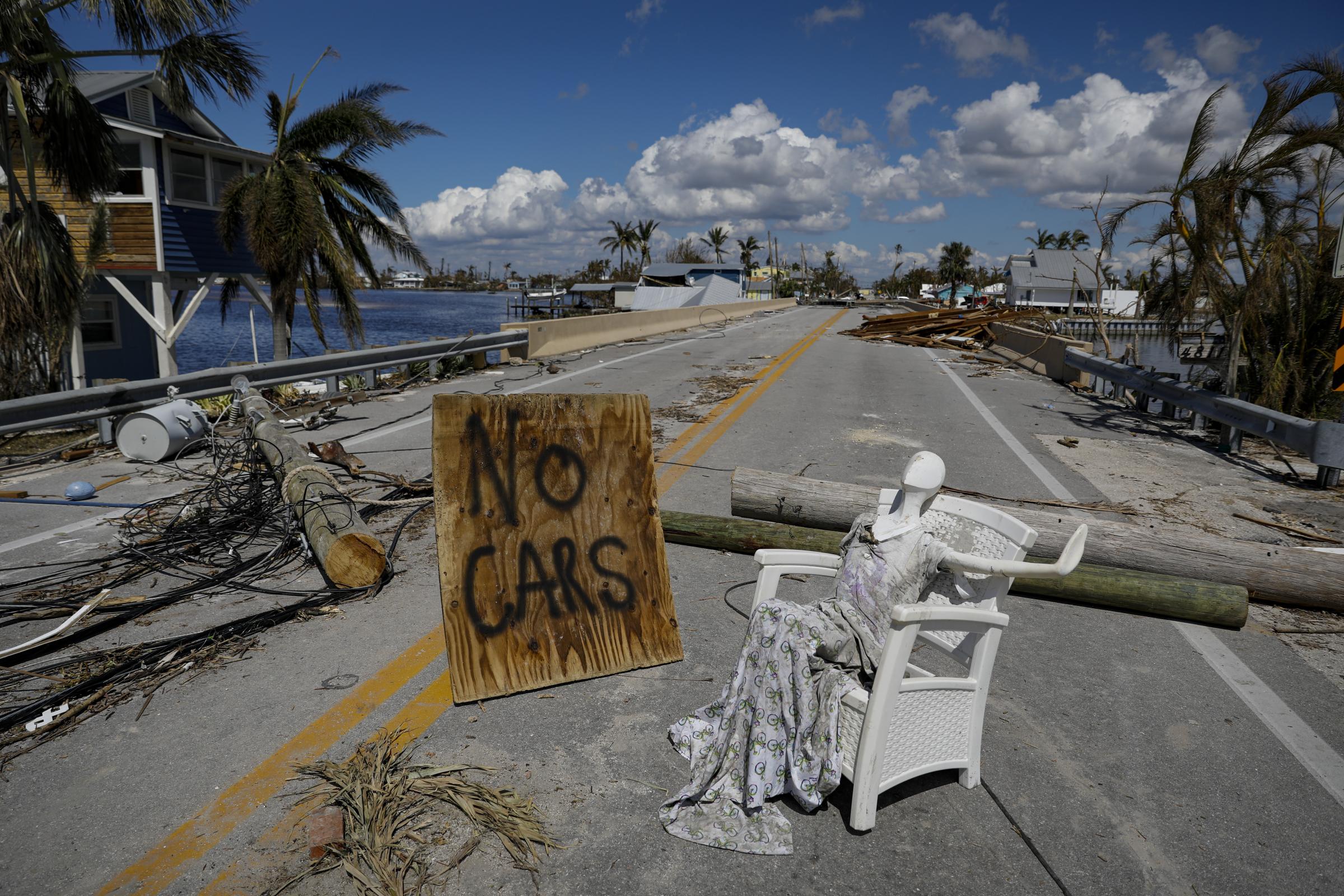 2022 - Hurricane Ian - A no car sign sits on a damaged road following Hurricane...