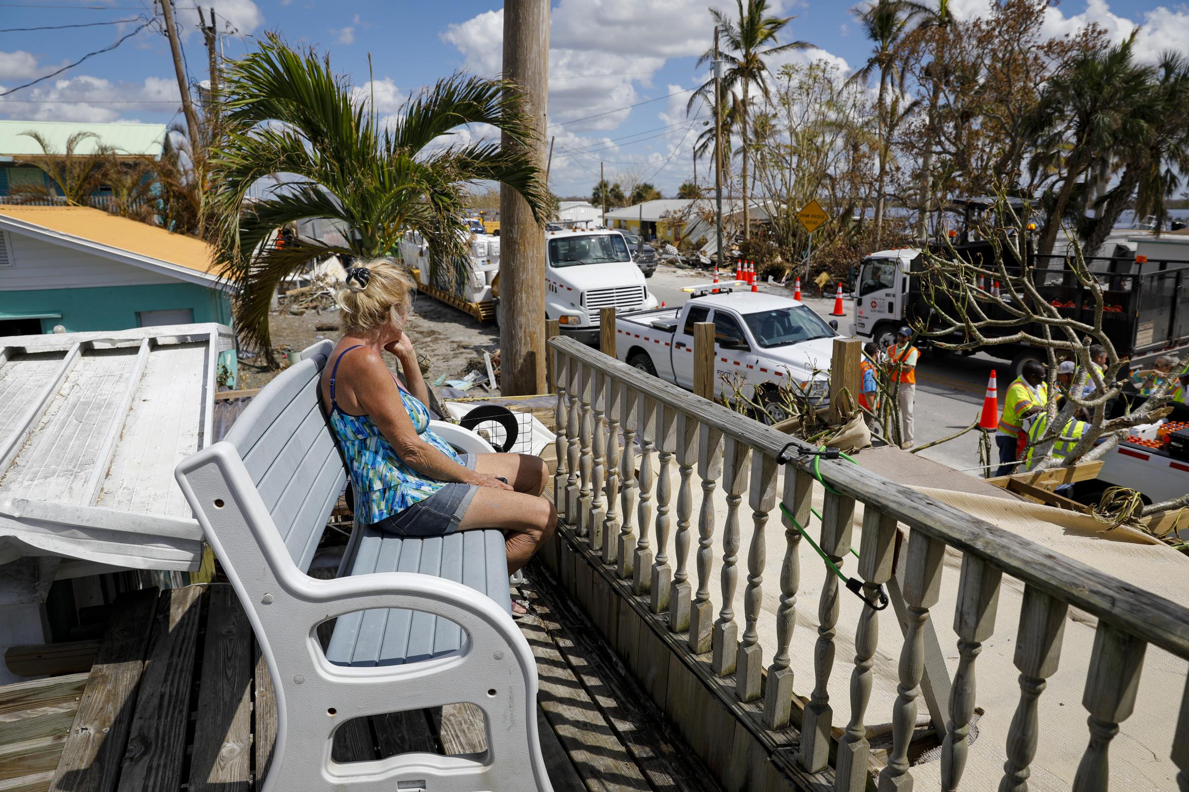 2022 - Hurricane Ian - A resident sits on the rooftop of her damaged house...