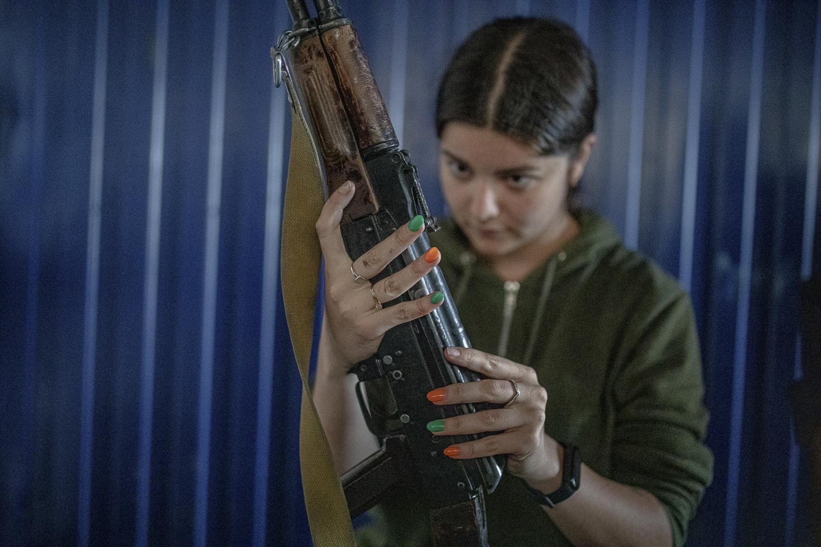 Defenders in training: empowering Ukrainian civilians amidst ongoing war - KYIV, UKRAINE - July 22, 2023: A woman with colored nail...
