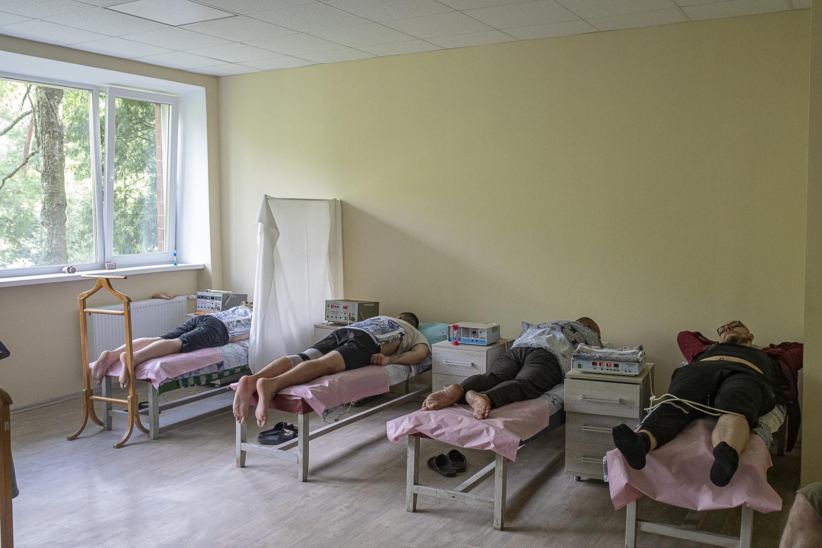 Walking wounded: a journey of recovery and hope - KYIV OBLAST, UKRAINE - JULY 21: Four soldiers lying on as...