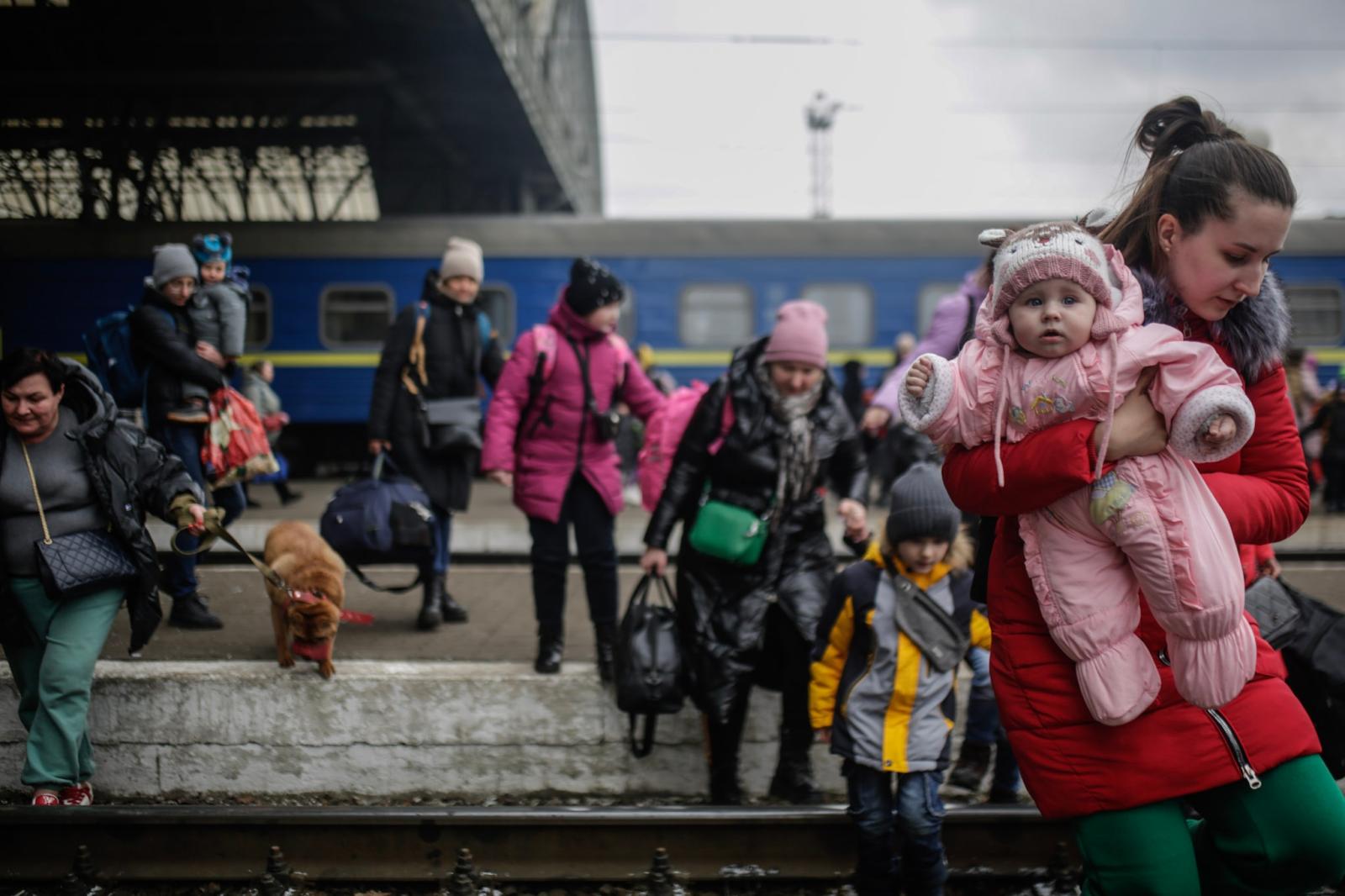 Infotalqual Refugiados entre Ucrania y Polonia - Mothers and children crossing Lviv railway lines,...