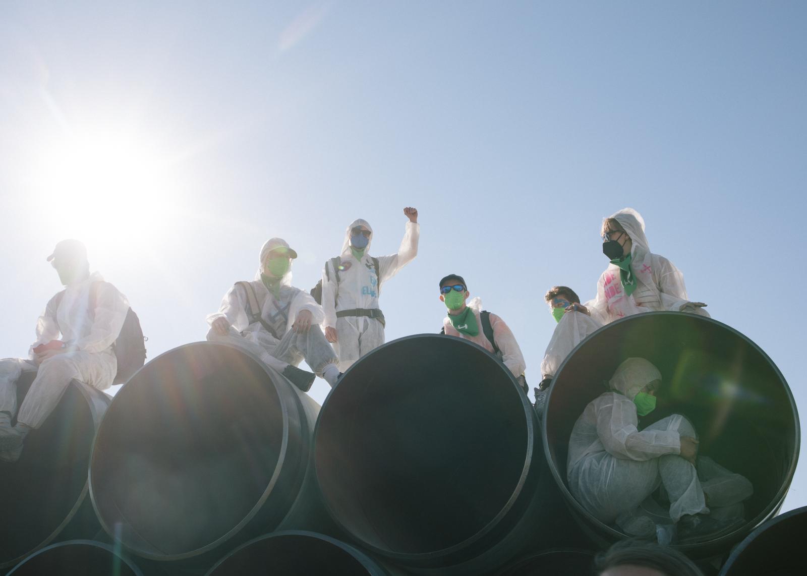 A week of protest against LNG, Neo-colonial Exploitation and Fossil Capitalism in Hamburg - Activists climb onto pipeline pieces, that are prepared...
