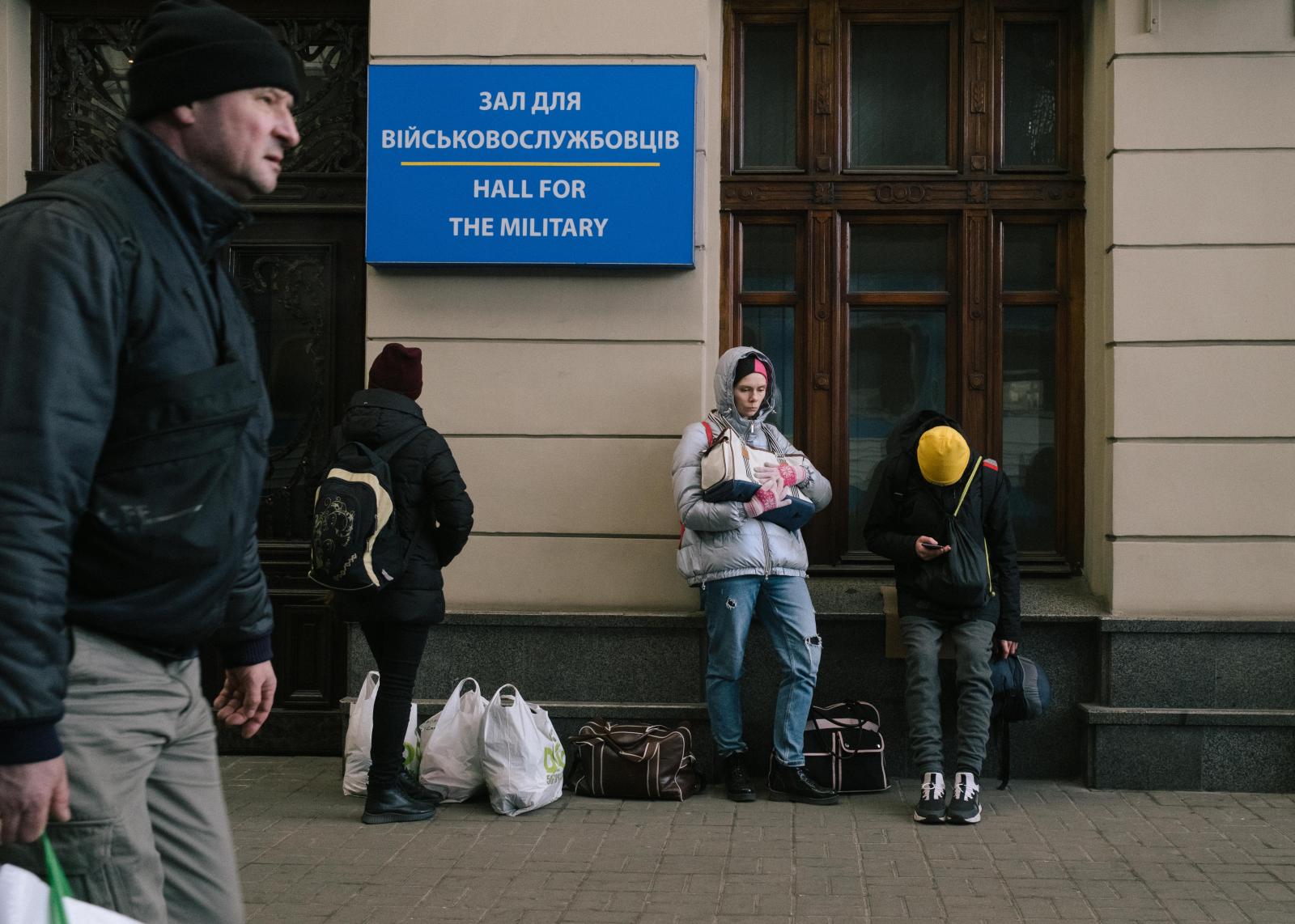 Escaping Putin's Bombs - A woman stands next to the "Hall of the...