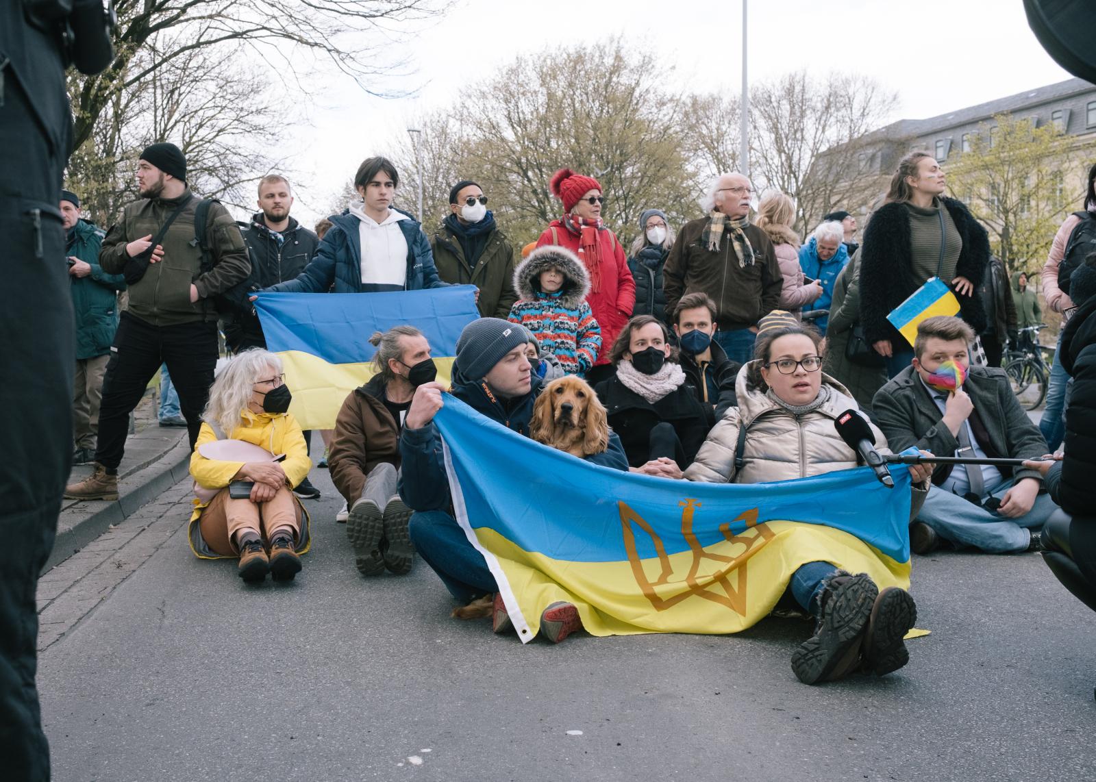 Protesters block motorcade with Ukranian flags.