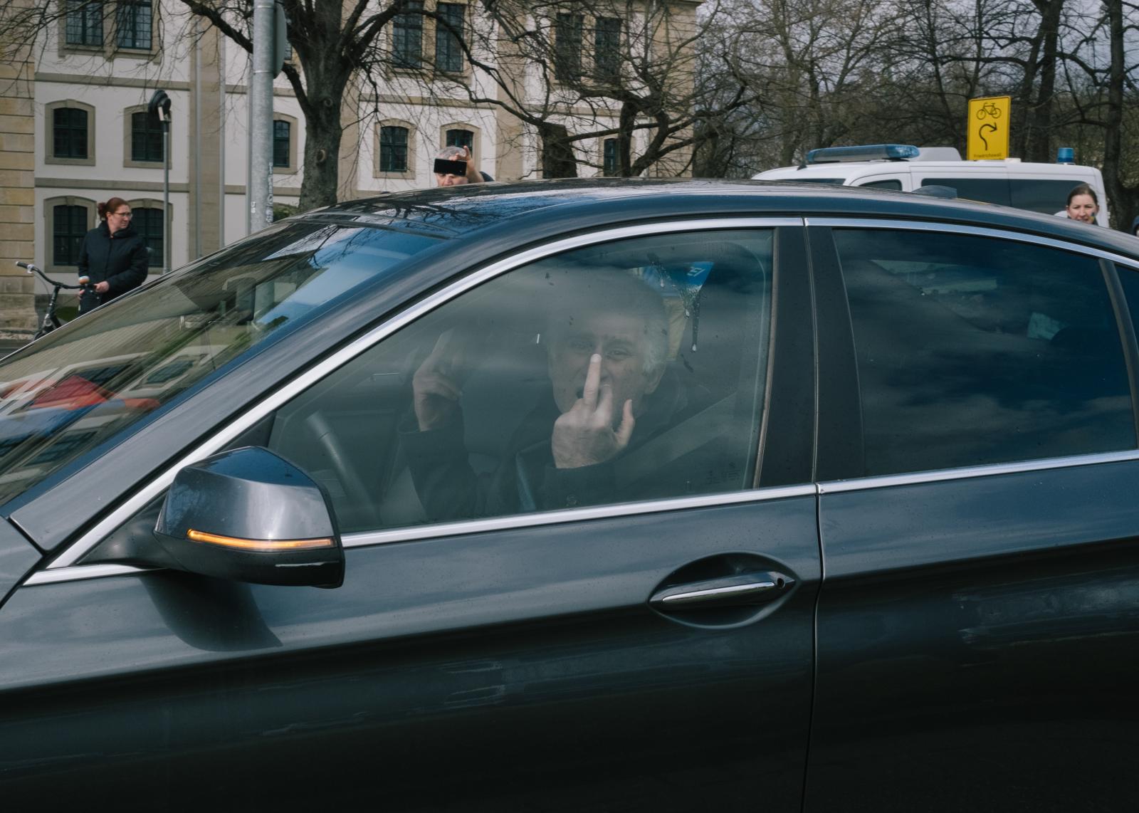 Russian Motorcade in Hanover Blocked - A participant of the motorcade waves middle-fingers at...