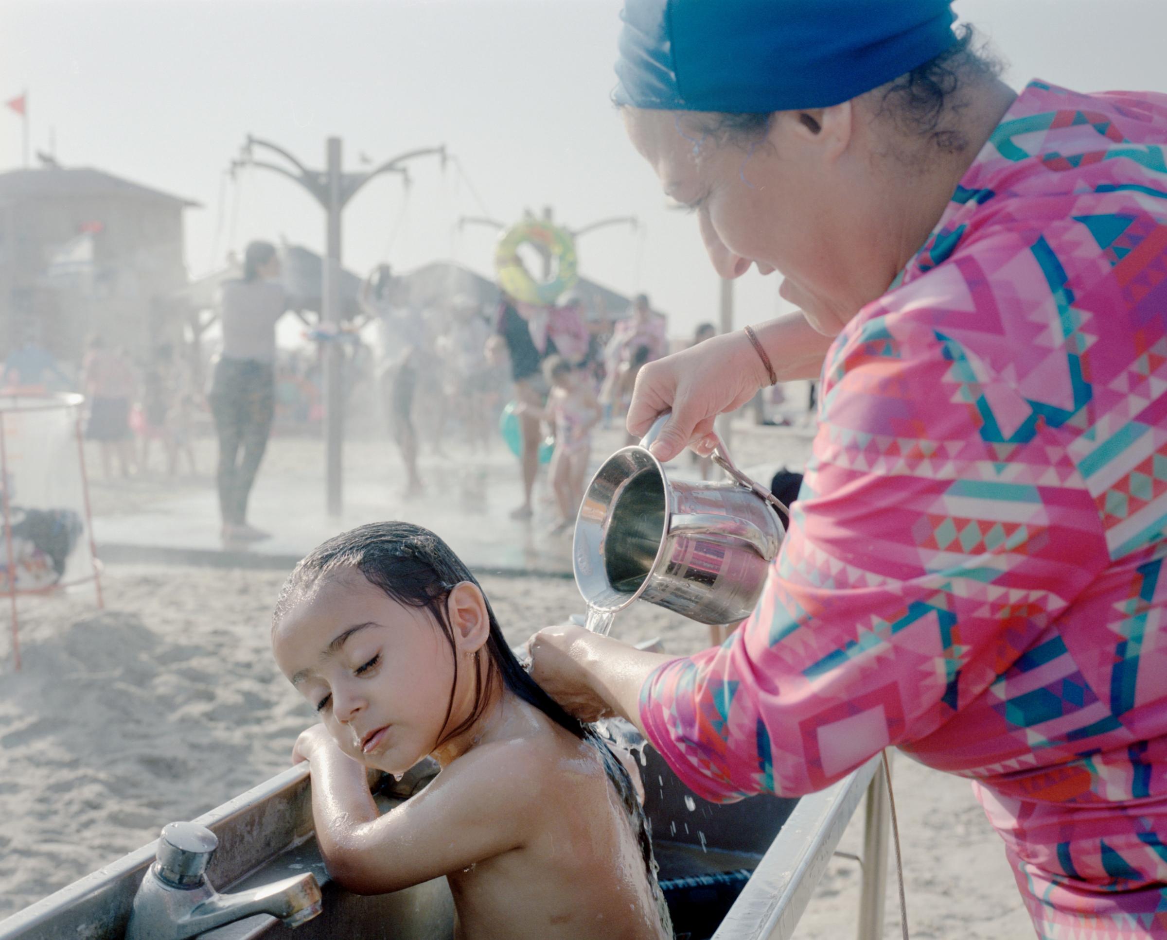 Three Times a Week (ong) -   A grandmother bathing her beloved granddaughter in the...