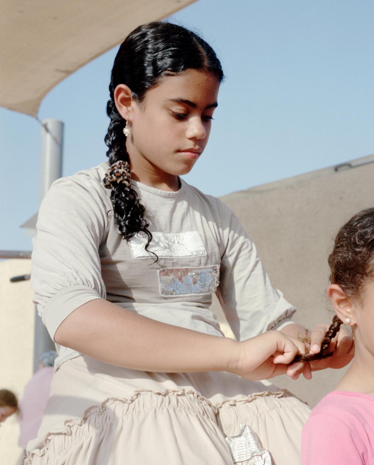 Three Times a Week (ong) -  Ayala, 12, braiding her cousin's hair. 