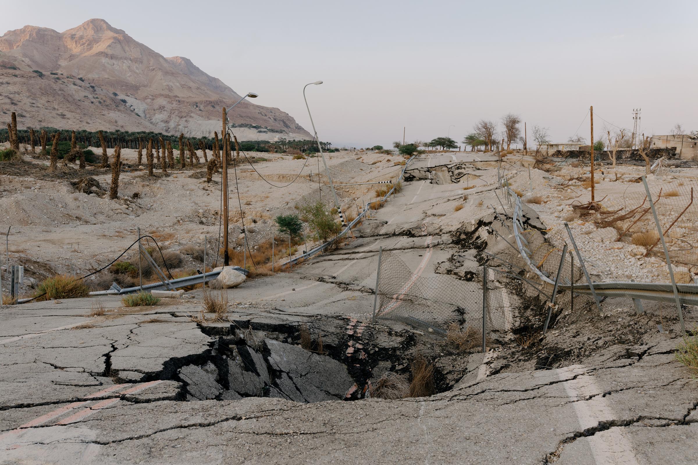 NPR - What is killing the Dead Sea? - A large sinkhole in the middle of the road in the Ein...