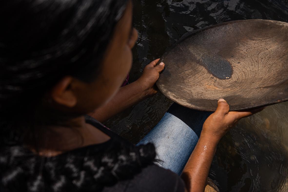 Sumak Kawsay: The Rights of Nature - Irena Alvarado is washing gold in a hand-made attribute...