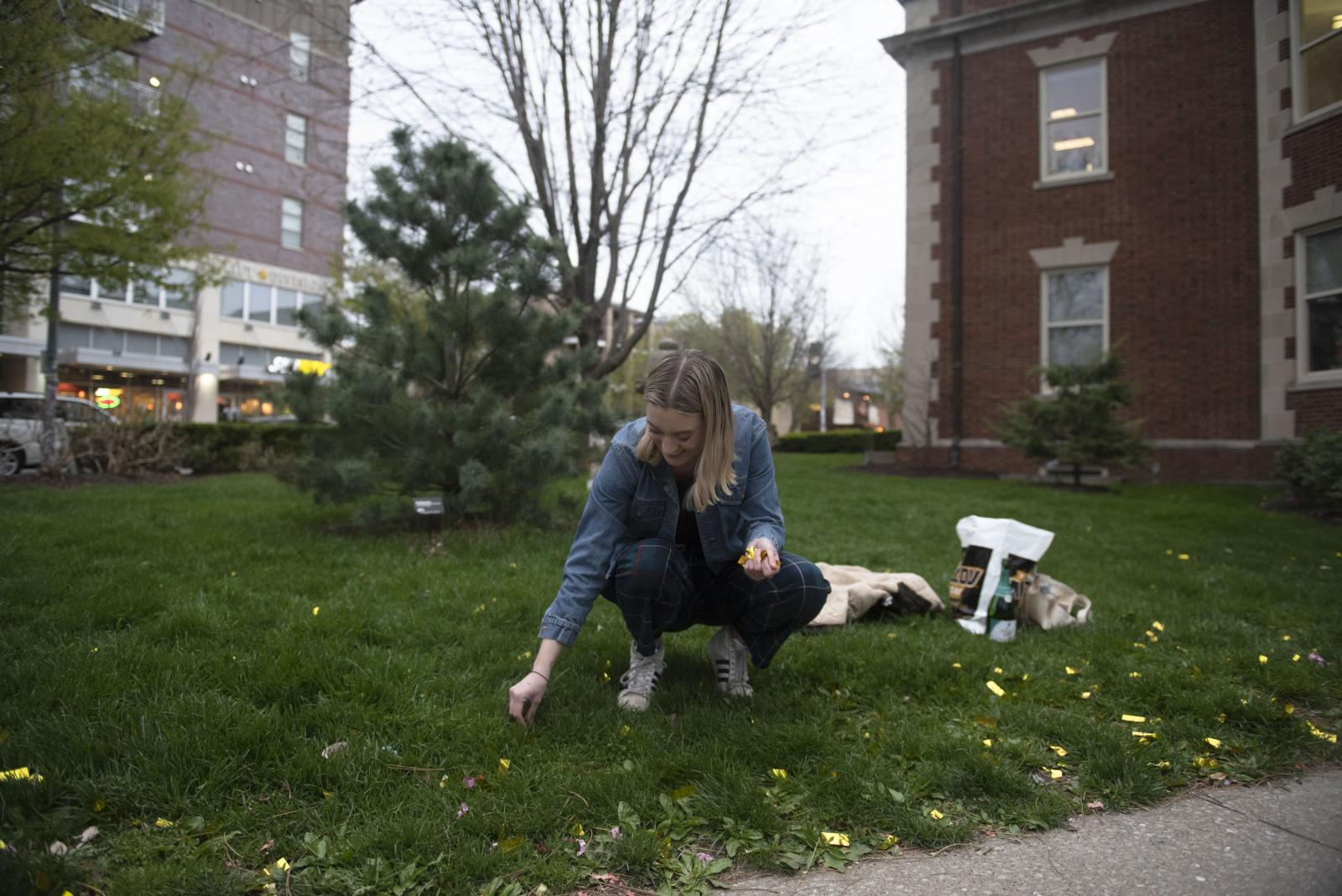 Kaleigh picks up discarded confetti to reuse for senior portraits April 19, 2022, at the University of Missouri in Columbia, Mo. Columbia 