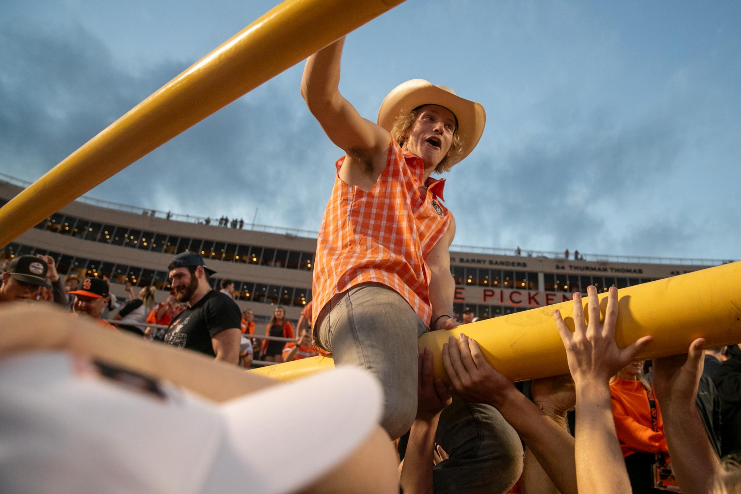 Sports - An Oklahoma State fan rides a goal post out of Boone...
