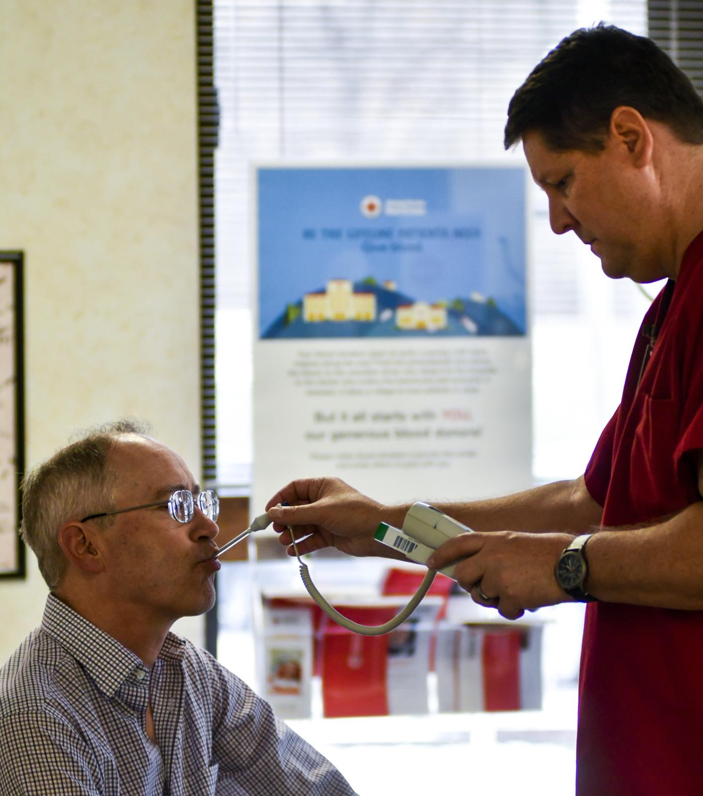 Eric Barnes, right, takes James Linsenbardt's, left, temperature on March 18, 2020, at the Red Cross Blood Donation Center in Columbia,...