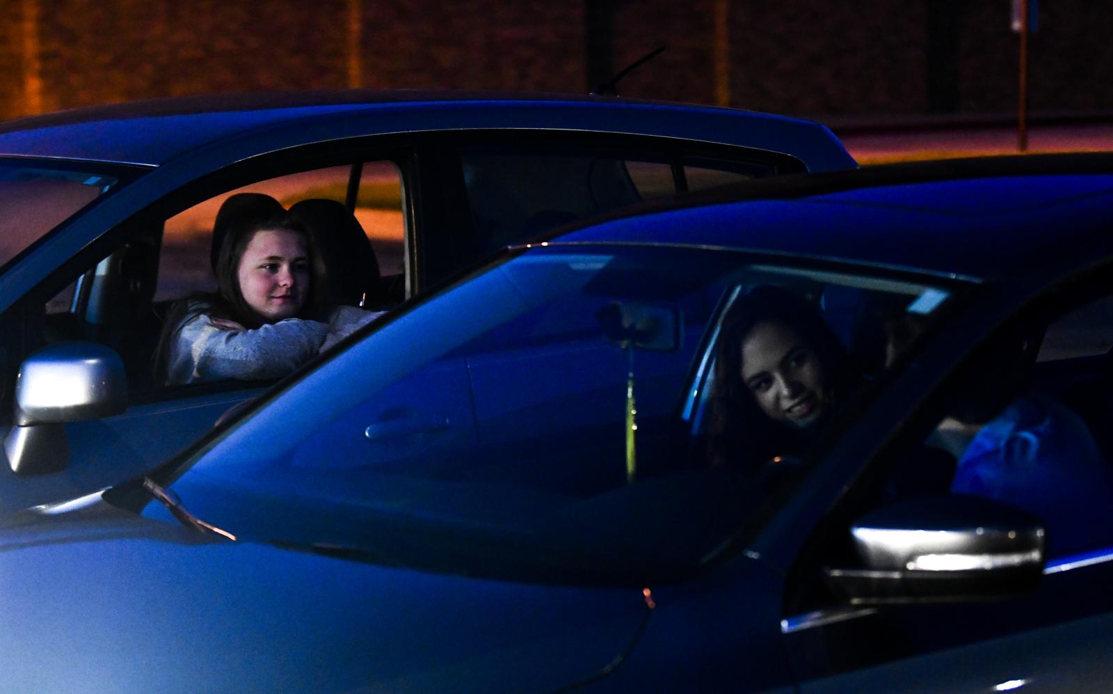 Rock Bridge seniors Madi Polnika, left, 18, Kennedy Robbins, center, 18, and Joseph Gard, right, 18, talk in the school parking lot on April 17, 2020 at Rock Bridge High School in Columbia, Missouri. The three talked about what was happening in their lives now that their year had been cut short due to the COVID-19 pandemic.