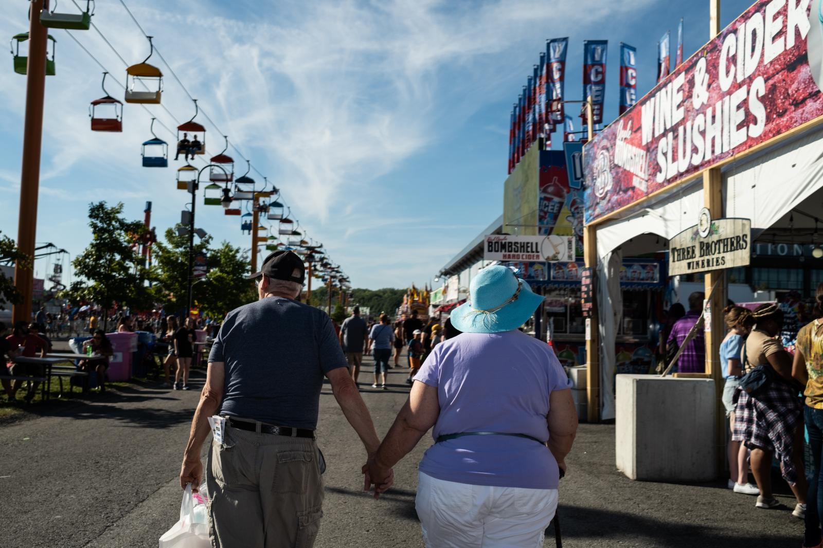 A couple walks hand in hand at the New York State Fair.&nbsp;