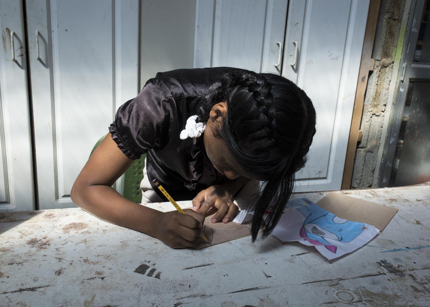 Bird's Nest - Andrea, 13, draws a teddy bear in the crafts workshop as...